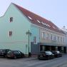 Bett & Rad Schöpf, Traismauer, © Familie Schöpf Straßenszene in Traismauer mit mehrstöckigem Gebäude und parkenden Autos.