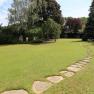 Gasthof zum Schwan, © Gasthof zum Schwan Ein gepflegter Garten mit einem geschwungenen Steinweg und Bäumen im Hintergrund.