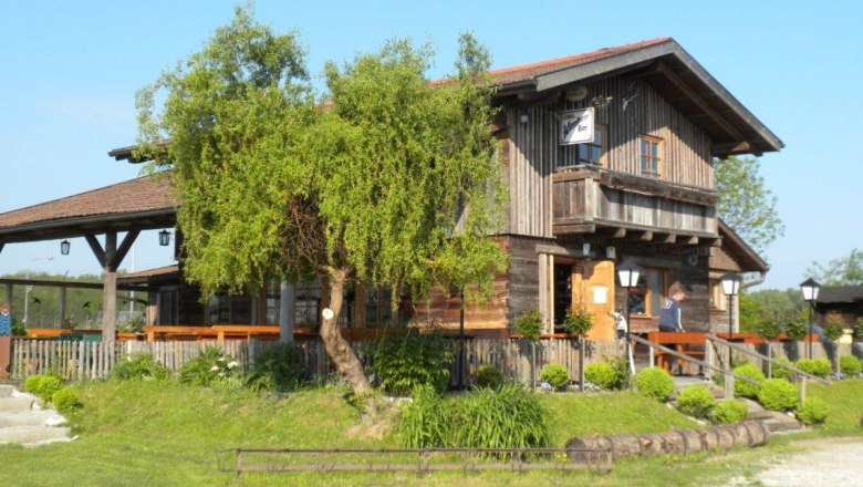 Bärndorfer Hütte, © Bärndorfer Hütte Eine rustikale Holzhütte mit Terrasse und Garten im Grünen, bei sonnigem Wetter.