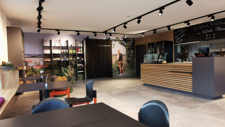 hofladen-klein, © Helmut Leonhartsberger Eingangsbereich mit Stühlen und einem Empfang aus Holz.