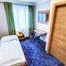 TDR-Smarthotel-EZ, © Schmid 1954 GmbH Einzelzimmer mit Schreibtisch und Fenster, blauer Teppich