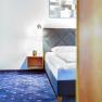 TDR-Smarthotel-DZ II, © Schmid 1954 GmbH Doppelschlafzimmer mit blauem Teppichboden und Doppelbett