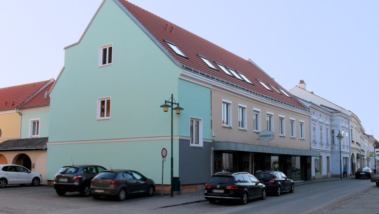 Bett & Rad Schöpf, Traismauer, © Familie Schöpf Straßenszene in Traismauer mit mehrstöckigem Gebäude und parkenden Autos.