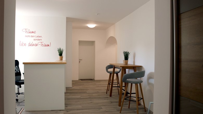 Bett & Rad Schöpf, Traismauer, © Familie Schöpf Moderner Innenraum mit Barhockern und Pflanzen auf einem Tisch.