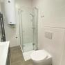 TDR-Smarthotel-Dusche, © Schmid 1954 GmbH Badezimmer mit Dusche und WC, weiße Fliesen