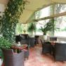 Rosenhotel, © Rosencafe Ein heller Wintergarten mit Korbmöbeln und vielen Pflanzen.