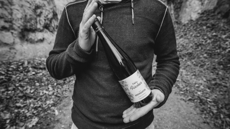 Flaschenpräsentation, © Tobias Singer Winzer präsentiert Weinflasche