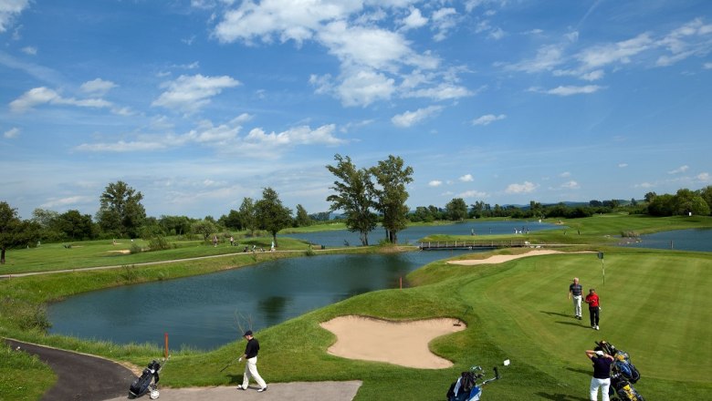 Diamond Country Club, © DCC Golfplatz mit Wasserhindernissen und Spielern unter blauem Himmel.