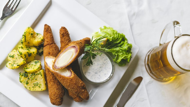 Gebackener Spargel, © Niederösterreich Werbung/David Schreiber Gebackener Spargel mit Kartoffeln, Salat und Bier auf weißem Teller.