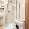 Modernes Badezimmer mit Dusche und Waschmaschine.