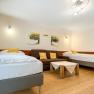 Schlafzimmer mit zwei Betten, Sofa und Tisch.