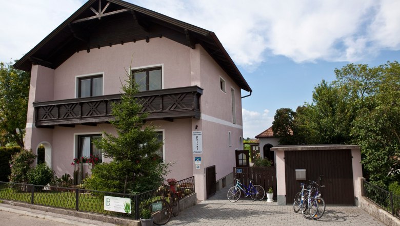 Stra&szlig;enansicht des Hauses mit gepflegtem Vorgarten und Einfahrt mit Garage.