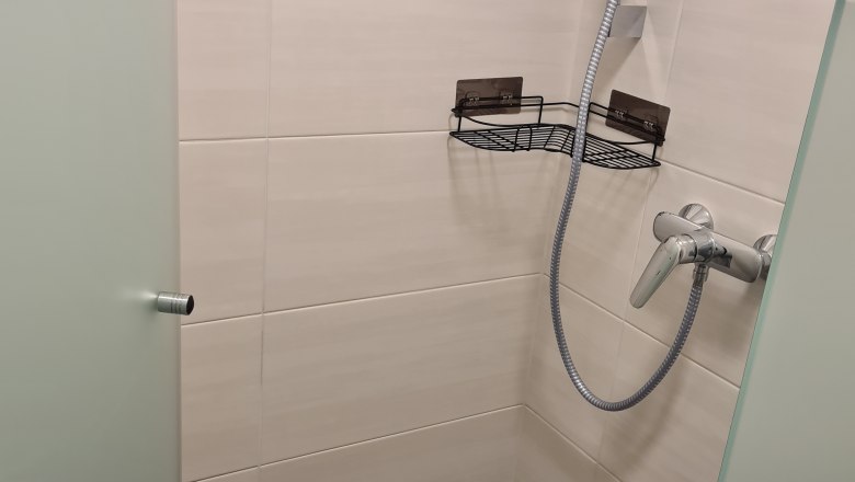 Moderne Dusche mit Glaswand und Duschkopf.