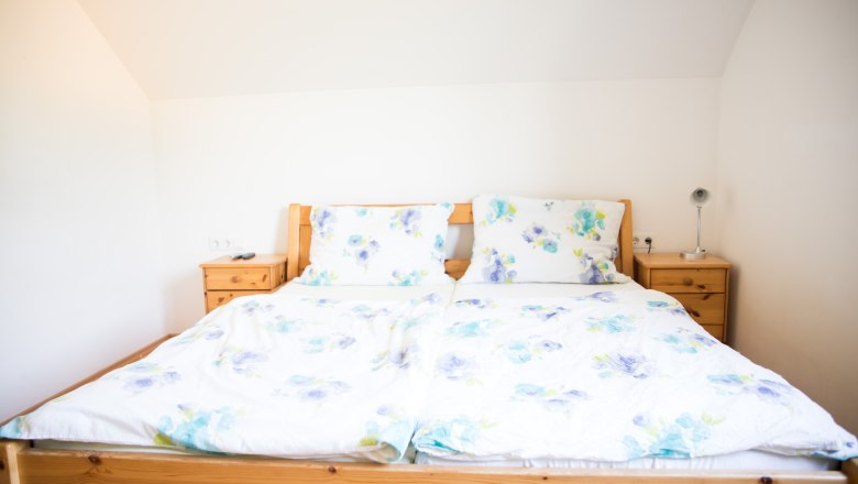 Doppelzimmer mit blumiger Bettwäsche