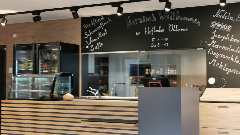 Detailansicht vom Hofladen. Theke und dahinter steht das Angebot auf einer Kreidetafel.