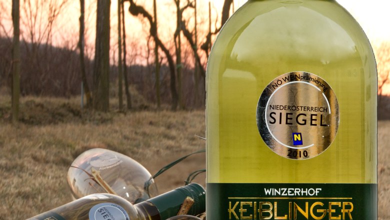 Weinflasche Keiblinger im Vordergrund, Weinberge im Hintergrund.