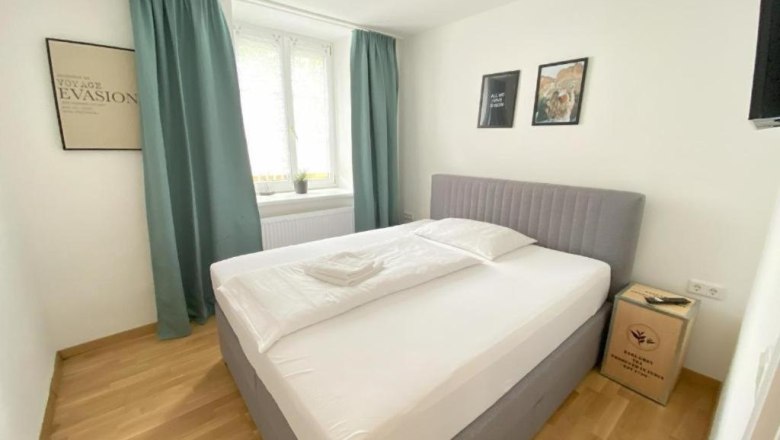 Doppelzimmer mit Holzboden und großem Fenster