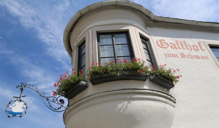 Fassade des Gasthofs zum Schwan mit Erker und Blumenkästen.