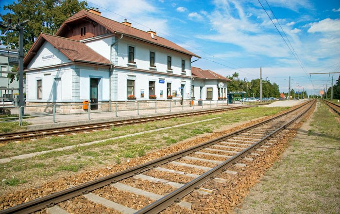 Bahnhof Traismauer mit Gleisen und blauem Himmel im Hintergrund.