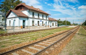 Bahnhof Traismauer mit Gleisen und blauem Himmel im Hintergrund.