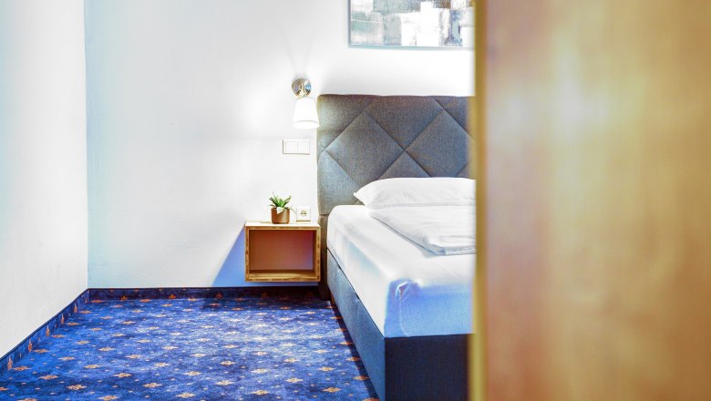 Doppelschlafzimmer mit blauem Teppichboden und Doppelbett