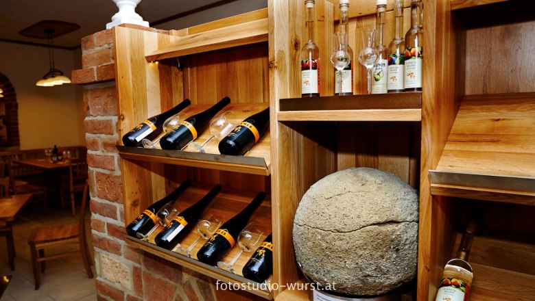 Weinflaschen platziert auf einem Regal im Lokal, © fotostudio-wurst.at