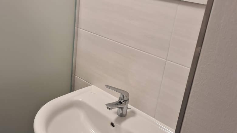 Modernes Badezimmer mit Waschbecken und Spiegel.